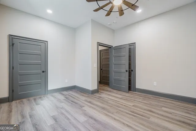 an empty room with closet and fan