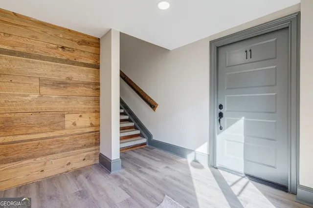 a view of an empty room with stairs and wooden floor