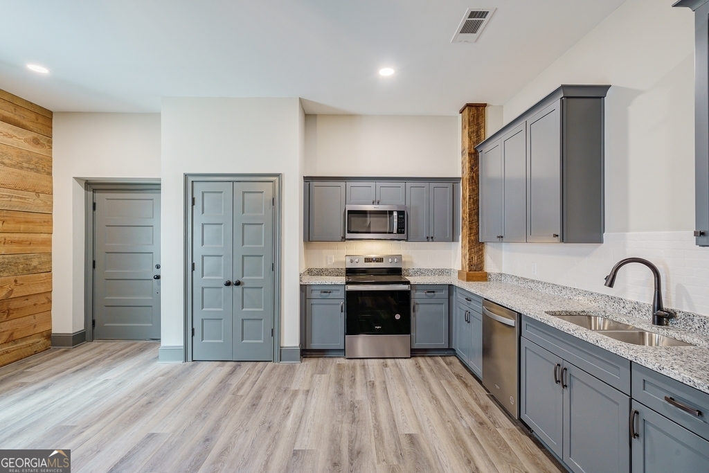 34 Depot Street, Unit 11 Hartwell, GA 30643 - Photo 9 of 21 a kitchen with stainless steel appliances granite countertop a sink stove and refrigerator