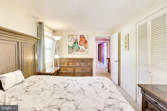 a bedroom with a bed and a dresser with mirror