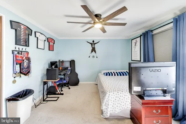 a bedroom with a bed dresser and a chandelier
