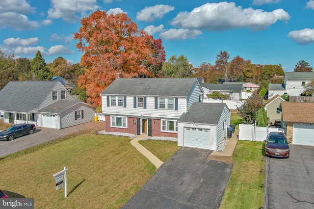 a view of a big house with a large trees and plants