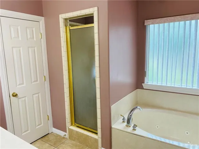 a bathroom with a tub sink and mirror