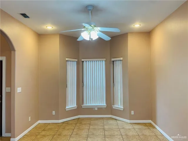 a view of a livingroom with a chandelier fan and windows