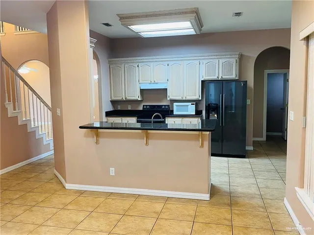 a kitchen with stainless steel appliances granite countertop a refrigerator and a stove
