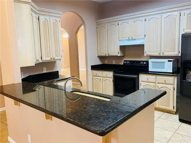 a kitchen with stainless steel appliances granite countertop a sink a stove and a microwave