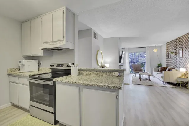 a kitchen with stainless steel appliances granite countertop a sink stove and cabinets