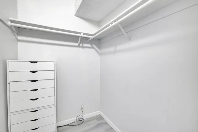 a view of walk in closet with empty racks