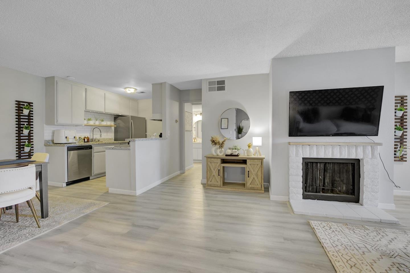 247 North Capitol Avenue, Unit 235 San Jose, CA 95127 - Photo 3 of 30 a living room with furniture a fireplace and a flat screen tv