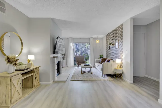 a living room with furniture a fireplace and a flat screen tv