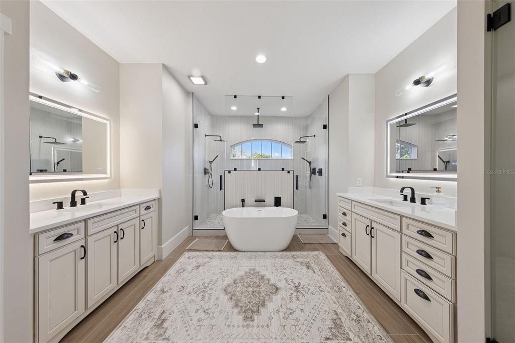 9126 Lake Coventry Court Gotha, FL 34734 - Photo 30 of 99 a large bathroom with a sink a large mirror and a toilet