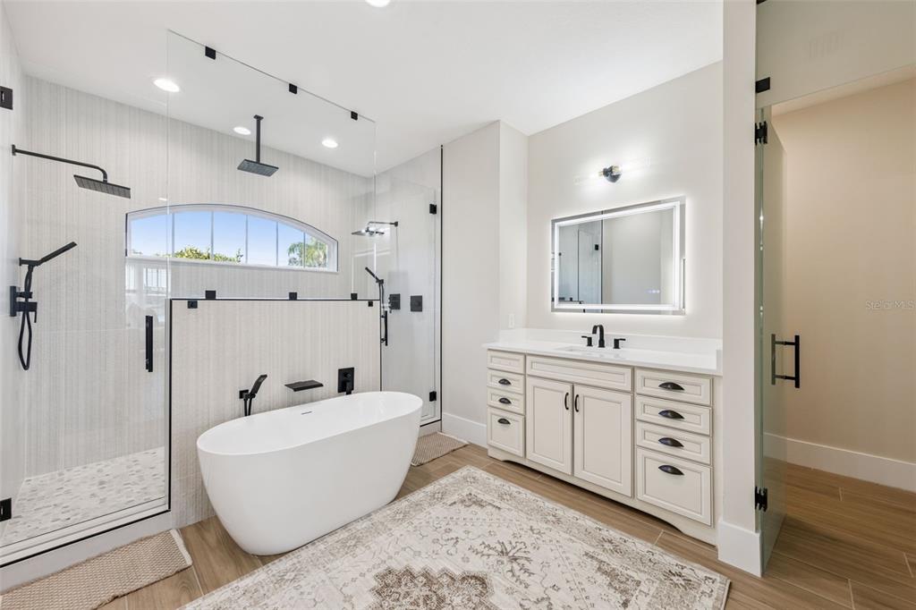 9126 Lake Coventry Court Gotha, FL 34734 - Photo 32 of 99 a spacious bathroom with a tub a double vanity sink a mirror a shower and vanity