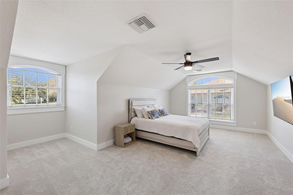 9126 Lake Coventry Court Gotha, FL 34734 - Photo 43 of 99 a spacious bedroom with a bed and a window