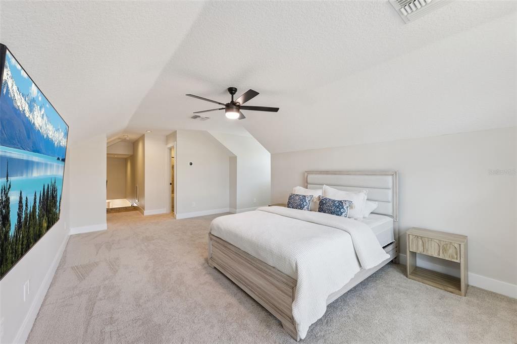 9126 Lake Coventry Court Gotha, FL 34734 - Photo 44 of 99 a bedroom with a bed and a chandelier