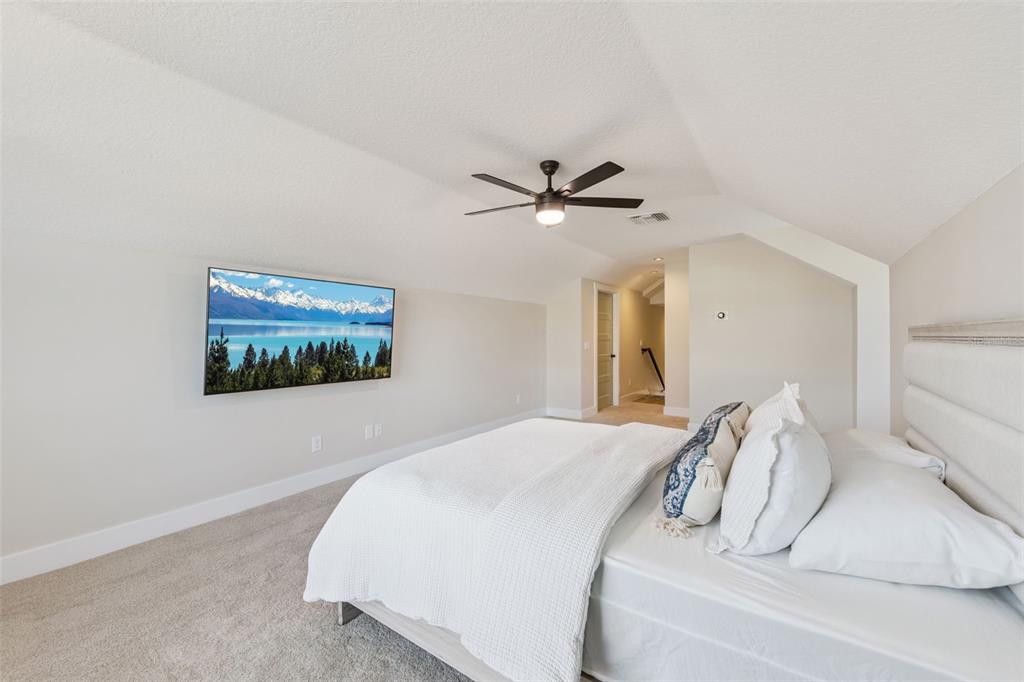 9126 Lake Coventry Court Gotha, FL 34734 - Photo 59 of 99 a bedroom with a bed and a ceiling fan