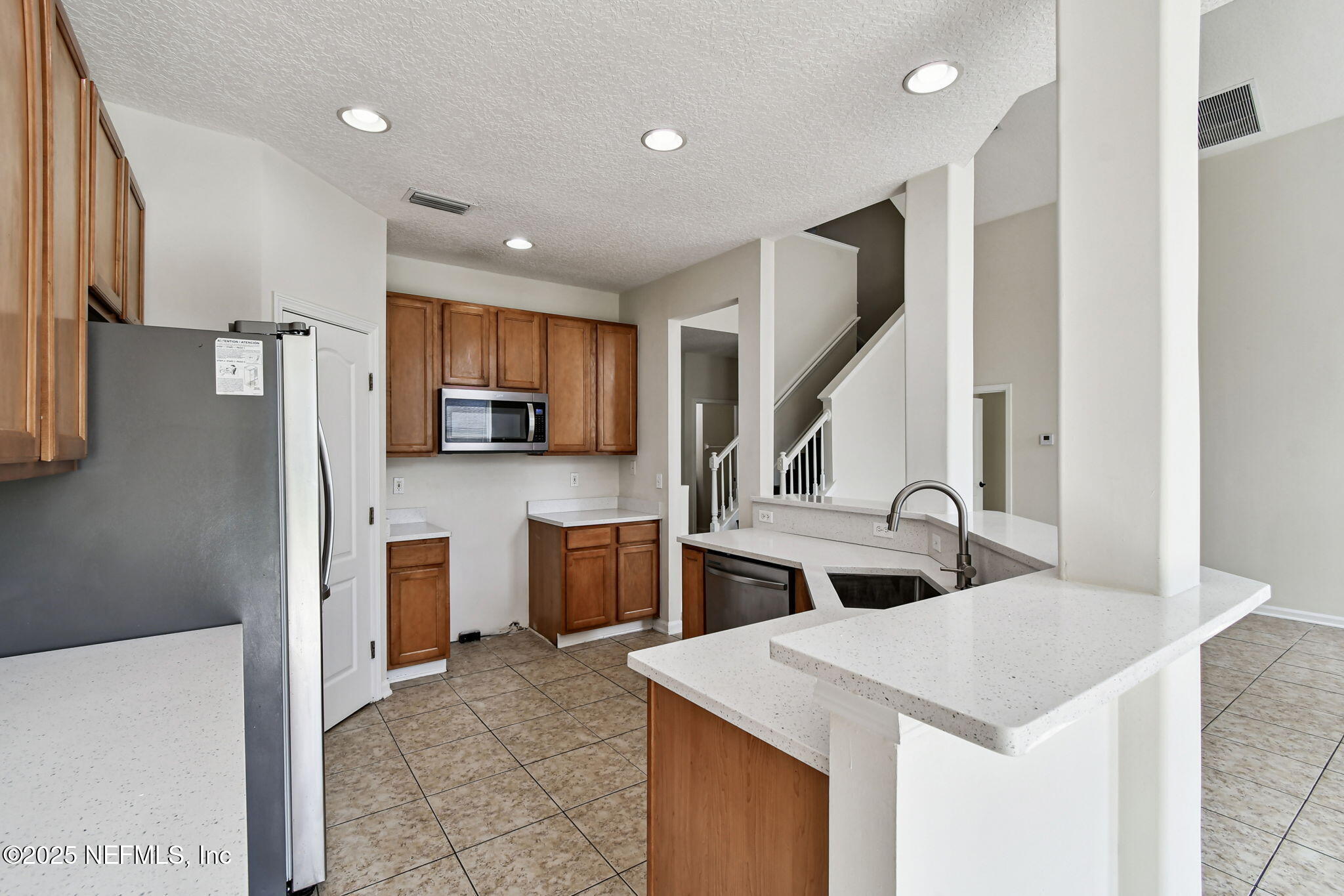 536 Spanish Wells Road Jacksonville, FL 32218 - Photo 14 of 45 a kitchen with white cabinets and stainless steel appliances