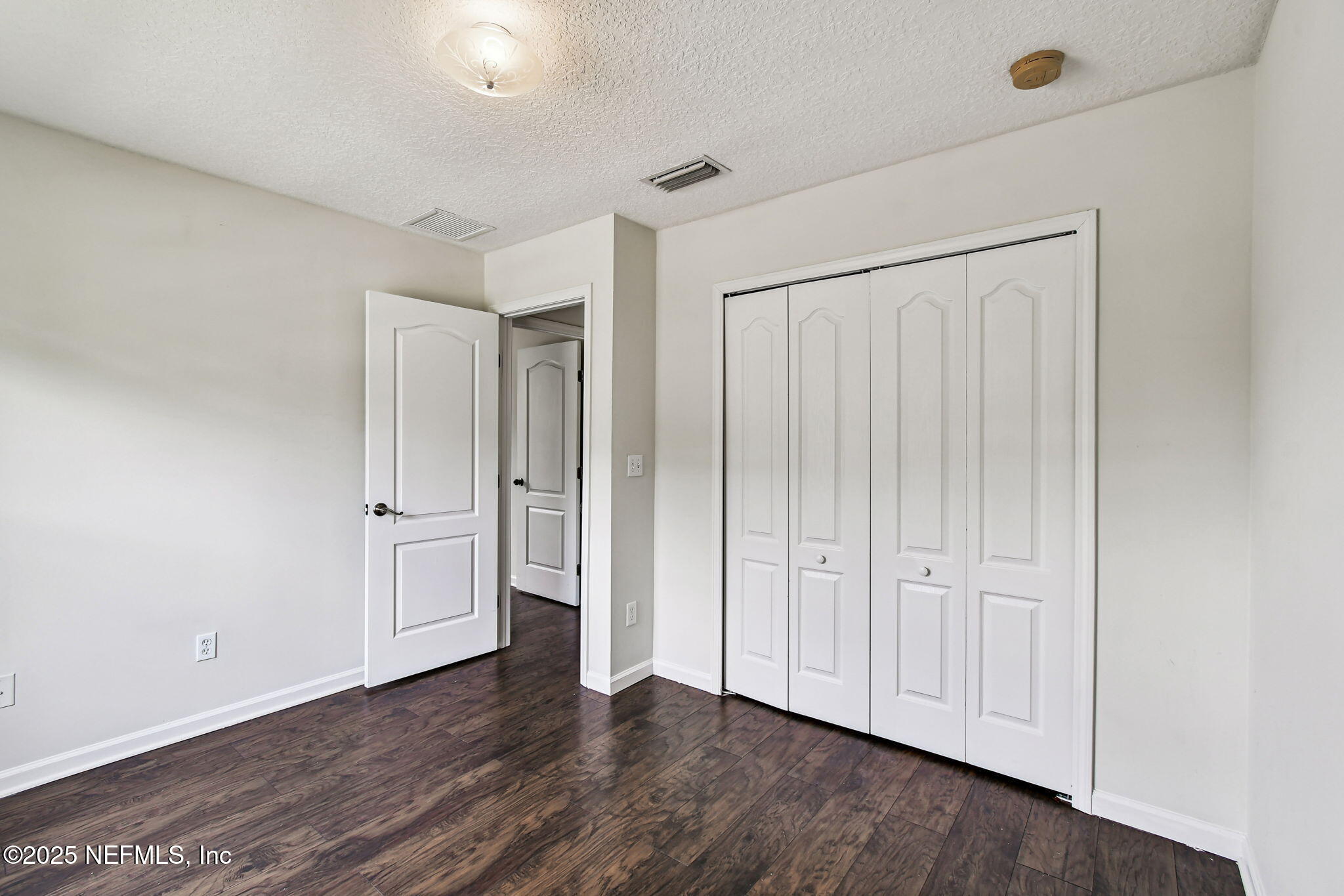 536 Spanish Wells Road Jacksonville, FL 32218 - Photo 30 of 45 an empty room with wooden floor and closet area