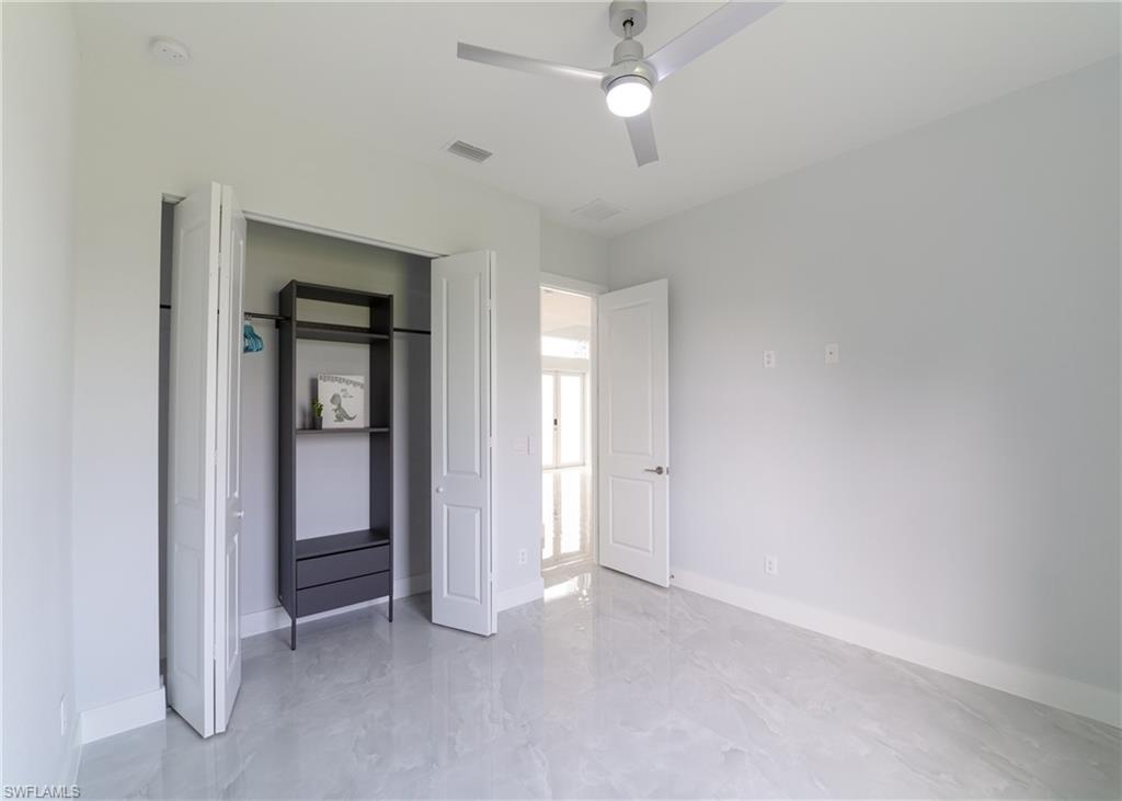 3408 12th Street Southwest Lehigh Acres, FL 33976 - Photo 12 of 47 an empty room with closet and a ceiling fan