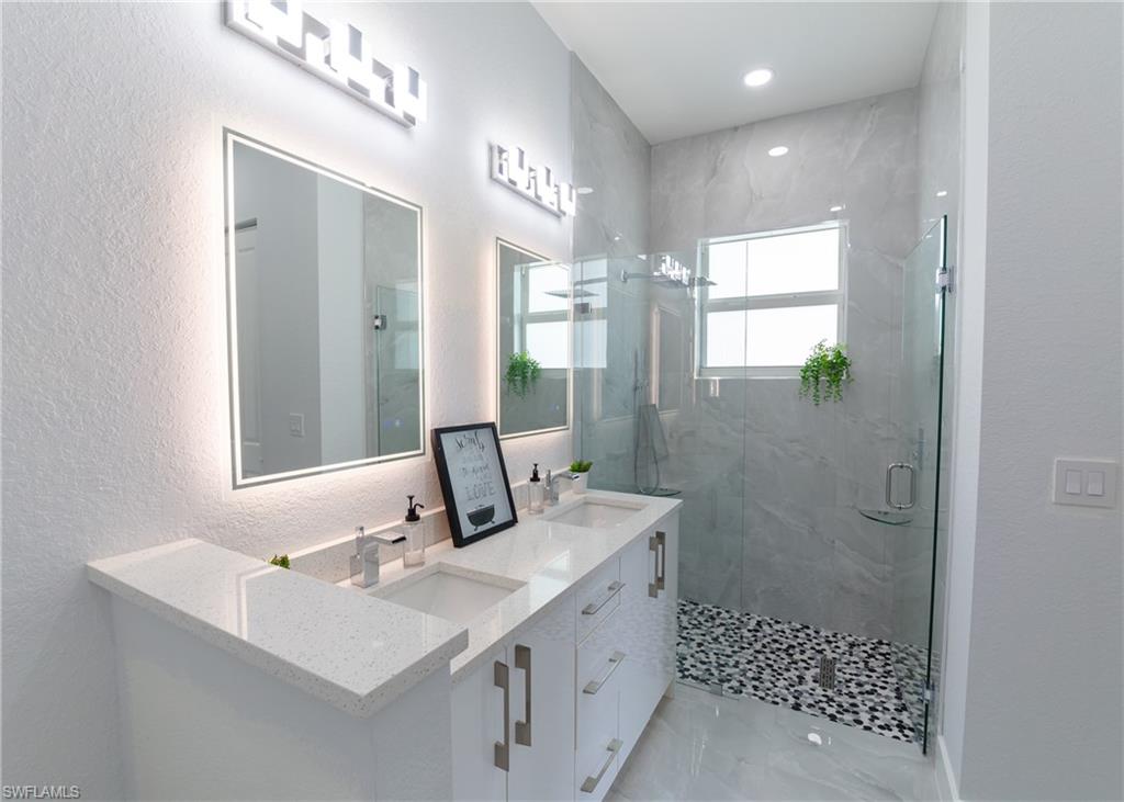 3408 12th Street Southwest Lehigh Acres, FL 33976 - Photo 15 of 47 a bathroom with a sink a toilet a mirror and shower