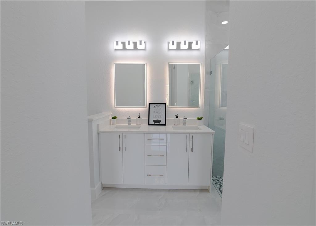 3408 12th Street Southwest Lehigh Acres, FL 33976 - Photo 17 of 47 a bathroom with a sink and a mirror