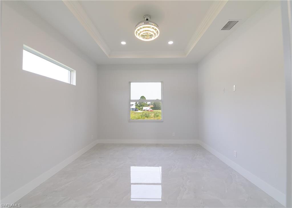 3408 12th Street Southwest Lehigh Acres, FL 33976 - Photo 20 of 47 an empty room with windows and with wooden floor