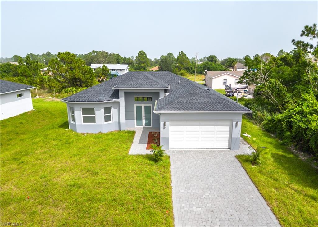 3408 12th Street Southwest Lehigh Acres, FL 33976 - Photo 46 of 47 a front view of a house with a yard