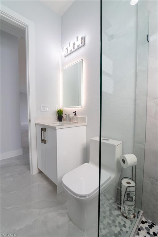 3408 12th Street Southwest Lehigh Acres, FL 33976 - Photo 6 of 47 a bathroom with a toilet a sink and a mirror
