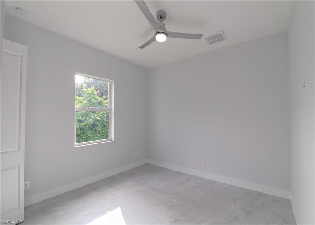 3408 12th Street Southwest Lehigh Acres, FL 33976 - Photo 9 of 47 an empty room with a window and a fan