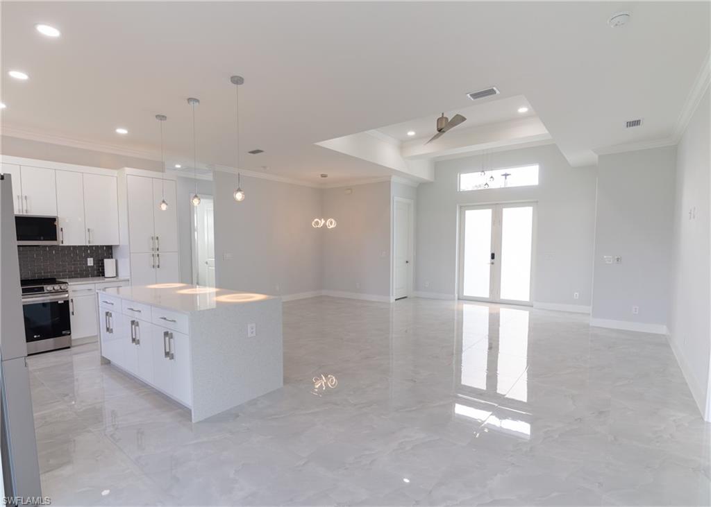 3408 12th Street Southwest Lehigh Acres, FL 33976 - Photo 10 of 47 a large white kitchen with cabinets