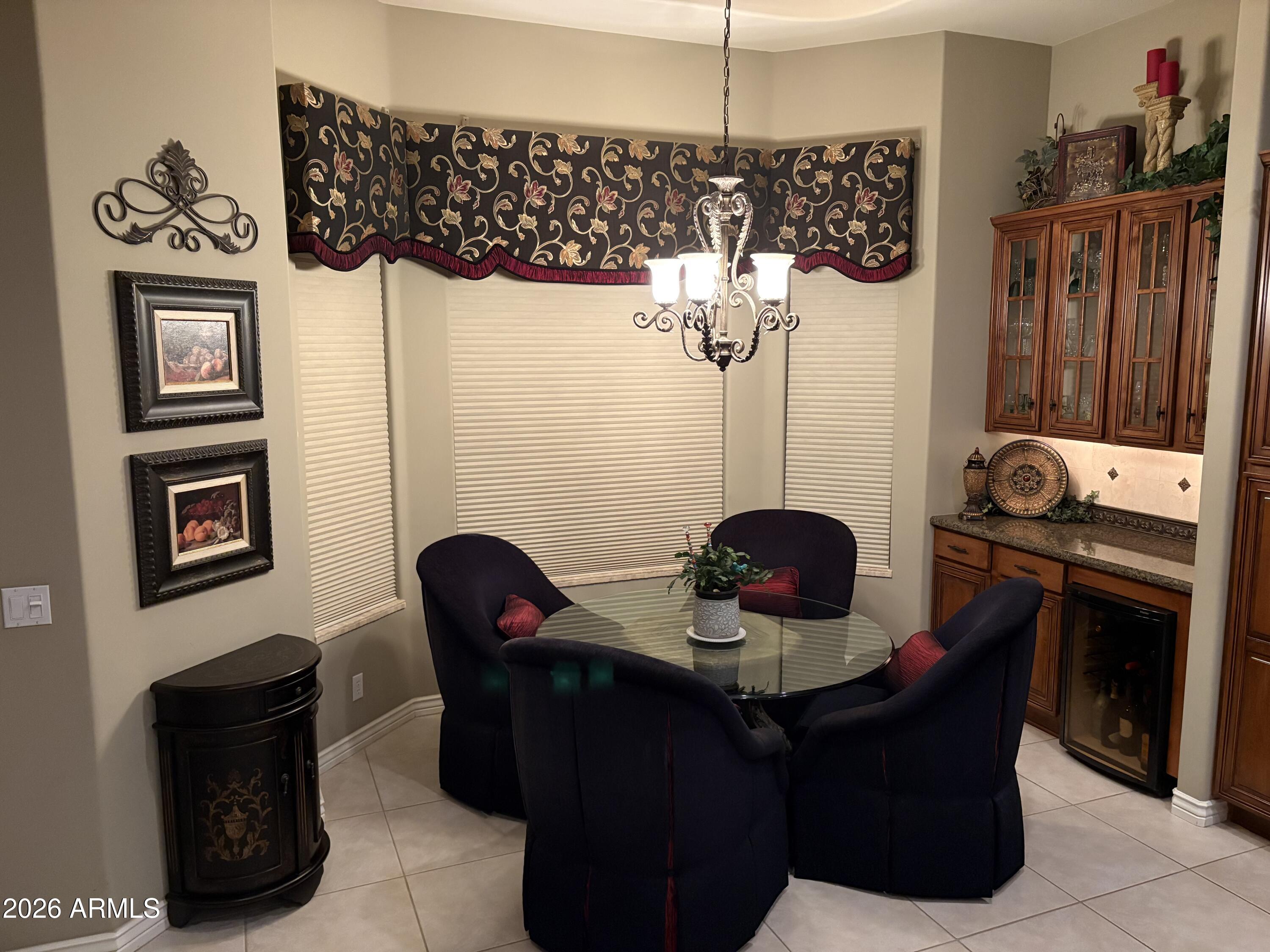 4055 North Recker Road Mesa, AZ 85215 - Photo 12 of 70 a living room with furniture a chandelier and a fireplace