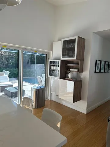 a living room with furniture a flat screen tv and a floor to ceiling window