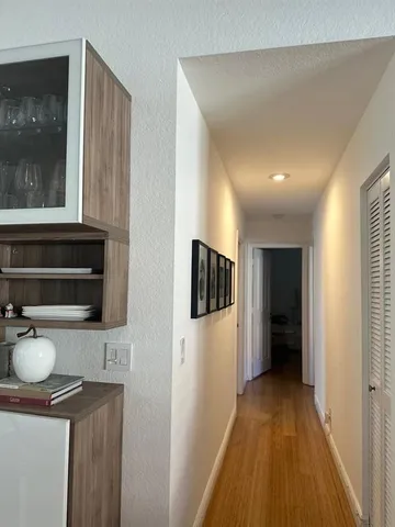 a view of hallway with wooden floor and flat screen tv