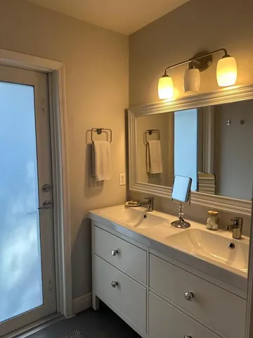 a bathroom with a double vanity sink and a mirror