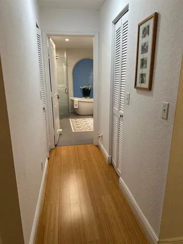 a view of a hallway with wooden floor and staircase
