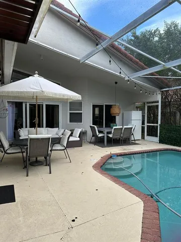 a view of a patio with table and chairs under an umbrella