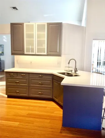 a kitchen with stainless steel appliances kitchen island granite countertop a sink and a wooden cabinets