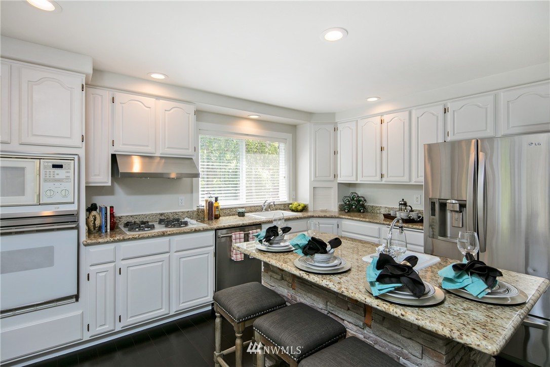 1511 232nd Place Southwest Bothell, WA 98021 - Photo 8 of 25 a kitchen with a sink stove and white cabinets