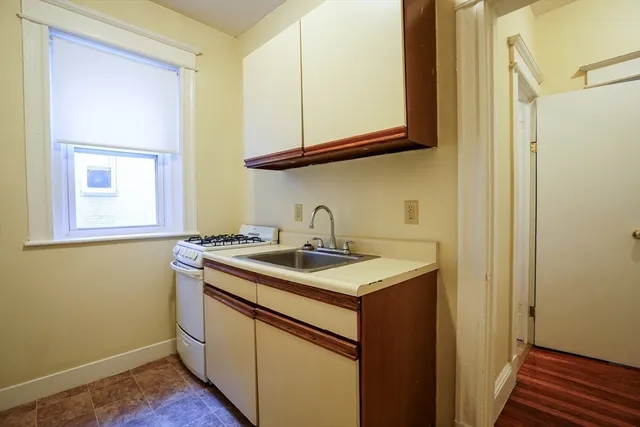 a view of a sink and dishwasher with wooden floor