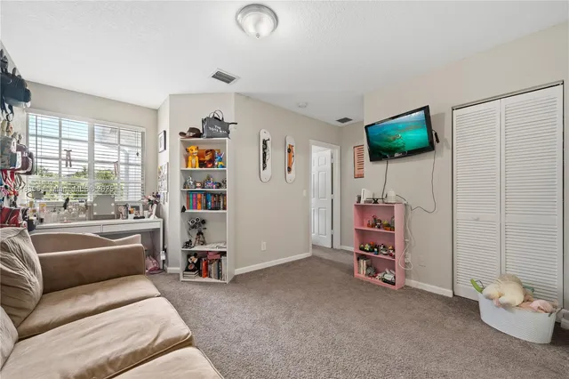 a living room with furniture a flat screen tv and a window