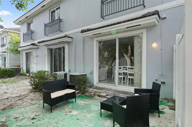 a view of a patio with couches table and chairs and potted plants