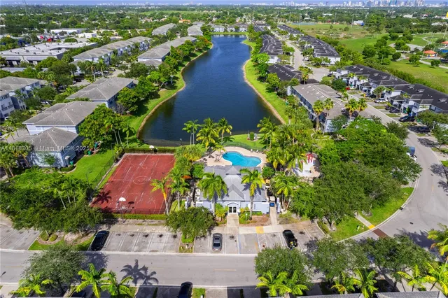 an aerial view of residential houses with outdoor space and trees all around