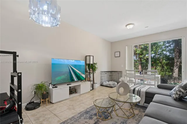 a living room with furniture a floor to ceiling window and potted plants