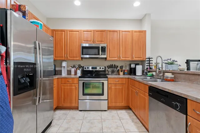 a kitchen with stainless steel appliances granite countertop a refrigerator stove top oven and sink