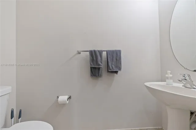 a bathroom with a toilet a sink and mirror