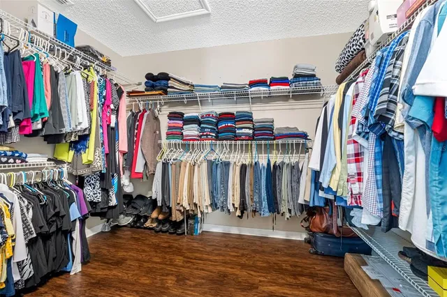 a bedroom with a bed and dresser with wooden floor