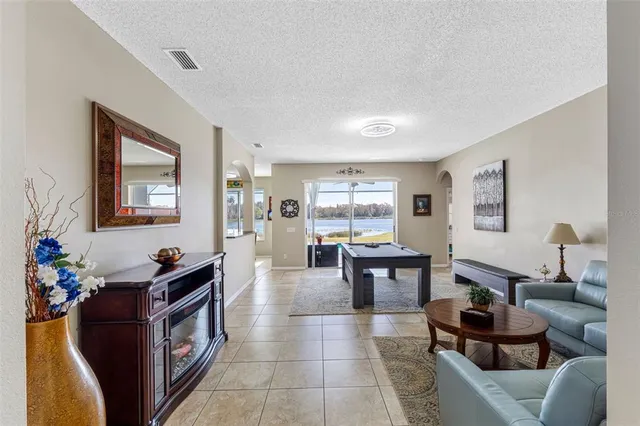 a living room with furniture a large window and wooden floor