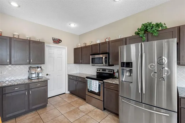 a kitchen with stainless steel appliances granite countertop a refrigerator stove and microwave