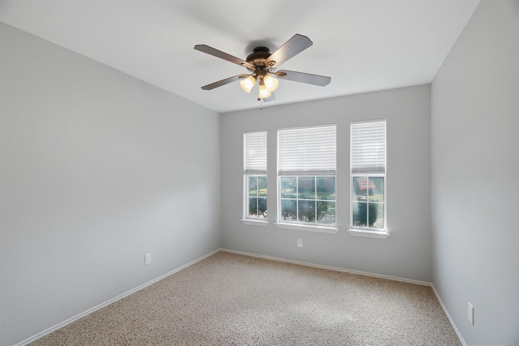 2074 Briarcliff Road Lewisville, TX 75067 - Photo 25 of 40 Room featuring three windows with blinds, light-toned carpeting, a ceiling fan with integrated lighting, and neutral wall finishes