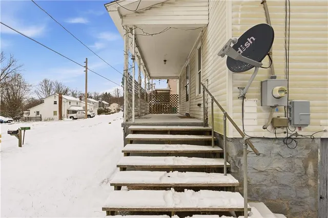 a view of a hallway with wooden floor and a bathroom