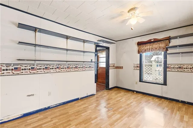 a room with kitchen island a large window cabinets and stainless steel appliances